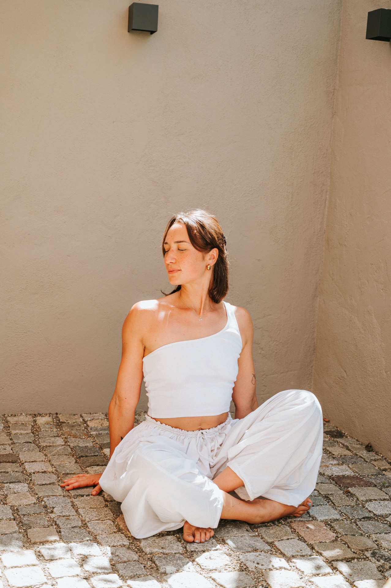 Yoga Studio Ostfildern – Frau in meditativer Yoga-Haltung im Sonnenlicht